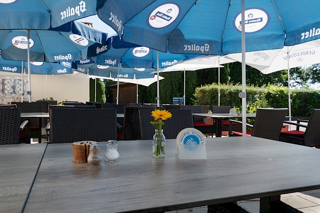 Blick in den gemütlichen Biergarten unter Sonnenschirmen
